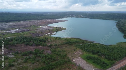 Aerial view of a former coal mining pit that holds water like a blue lake, environmental damage