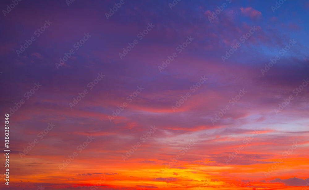 Fototapeta premium Beautiful sunset and sunrise skies, with purple and orange clouds in various colors,Panoramic view of a breathtaking sunset sky featuring a dramatic blend of purple, pink, and golden orange clouds.