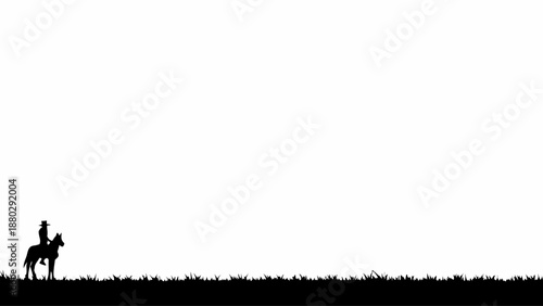 Silhouette of cowboy riding horse across serene grassy landscape