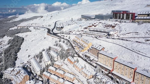 Aerial 4K video from a drone to Sierra Nevada ski resort on a sunny winter day in the mountains, Spain. Sierra Nevada is the largest mountain range near the city of Granada in Spain with snow. Sierra 