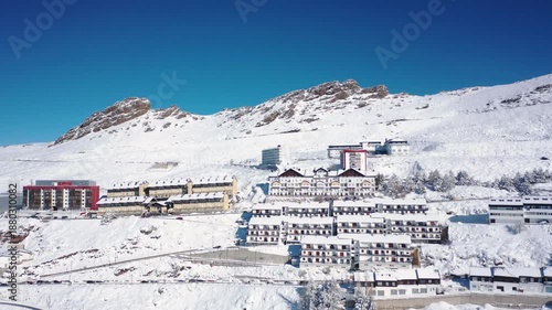 Aerial 4K video from a drone to Sierra Nevada ski resort on a sunny winter day in the mountains, Spain. Sierra Nevada is the largest mountain range near the city of Granada in Spain with snow. Sierra 