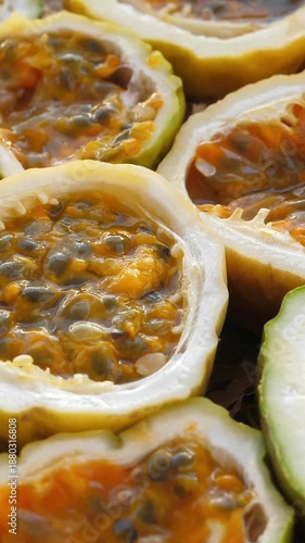Passion fruit background with half cut chinola. A lot of sliced maracuja. Tropical fruits backdrop. Vertical footage