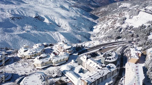 Aerial 4K video from a drone to Sierra Nevada ski resort on a sunny winter day in the mountains, Spain. Sierra Nevada is the largest mountain range near the city of Granada in Spain with snow. Sierra 