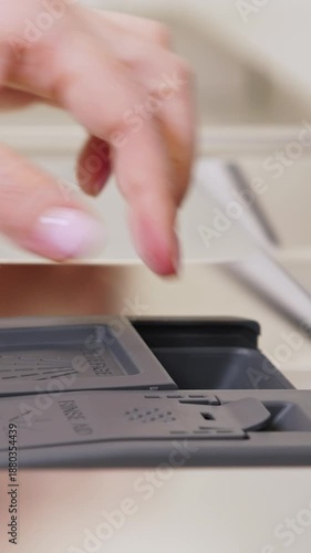 Wallpaper Mural Female hand puts soap tablet to dishwasher detergent box, closeup. Vertical footage Torontodigital.ca