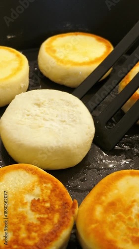 Wallpaper Mural Cooking cheesecakes on frying pan. Closeup. Vertical footage Torontodigital.ca