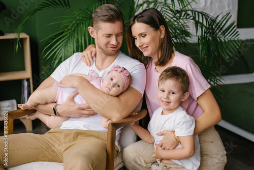 Loving Parents With Baby And Toddler Smiling