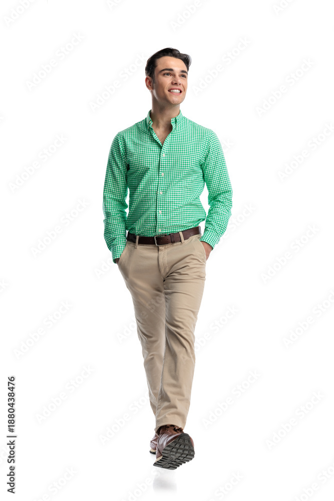 Naklejka premium Cheerful young man walking forward looking to side