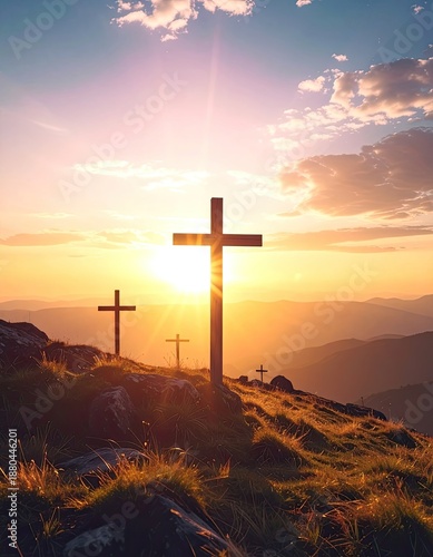 Multiple wooden crosses silhouetted against a vibrant mountain sunset.