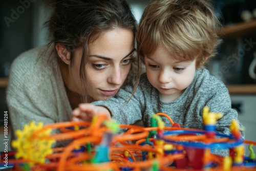 Mother watches her young child happily engaged in creative play with colorful educational toys in a cozy indoor setting