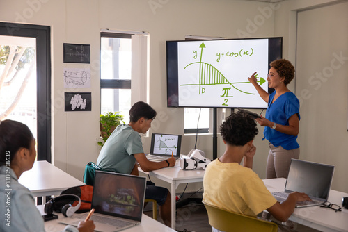 Valokuva African american female instructor pointing at cosine curve on classroom display