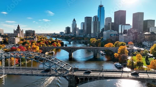 Cityscape with bridges over river and autumn trees in urban scenery