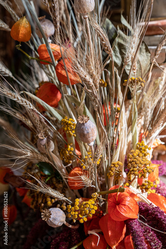 Wheat and poppy heads in a rustic vase as natural floral decoration