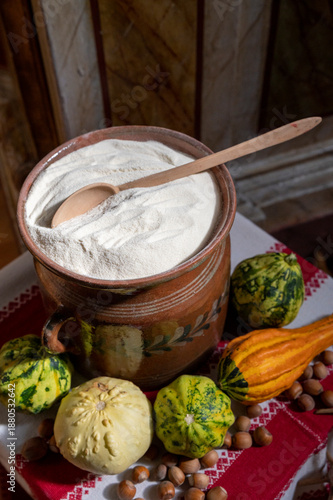 Freshly ground flour in a large ceramic jar with a wooden spoon.