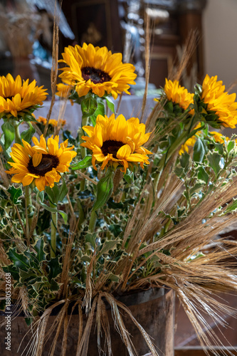 Sunflowers in a vase with wheat stalks as rustic floral arrangement