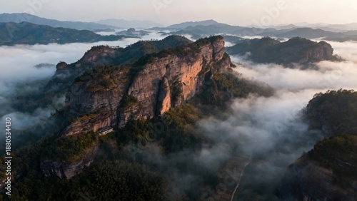 Majestic mountain cliffs rising above a sea of clouds at dawn