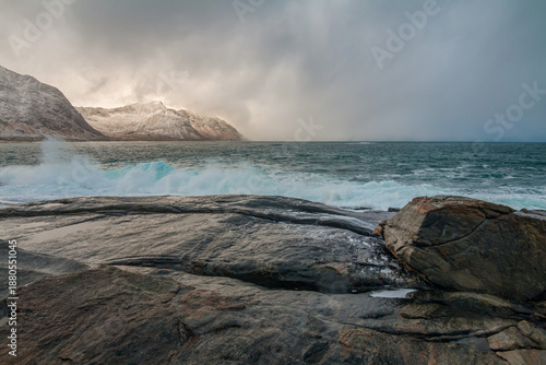 Cloudy day on the coast of Senja, Norway, with dramatic cliffs, rough sea waves, and a moody sky creating a powerful, atmospheric Nordic seascape shaped by wind and nature