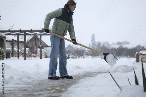 Wallpaper Mural Young woman shoveling snow. Winter lifestyle. Removing snow after blizzard. Torontodigital.ca