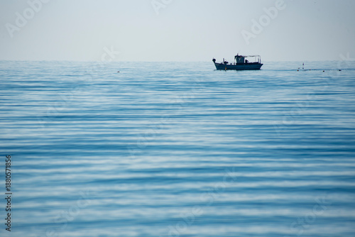 A small fishing boat fishing near the beach