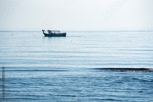 A small fishing boat fishing near the beach