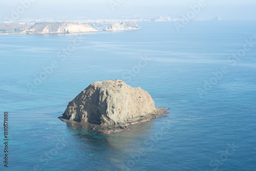 Rocky island in the sea on a background of blue sky.