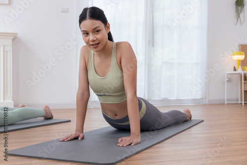 Teenage girls practicing yoga poses, trainer stretching muscles in the morning at home