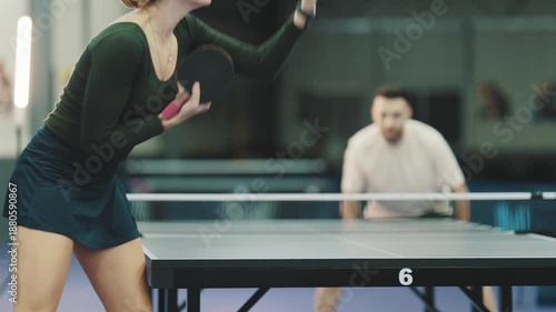 Determined woman serving ball during table tennis match