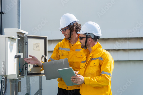 Engineers inspecting rooftop electrical equipment