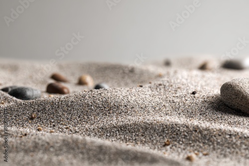 Close-up of Fine Grains of Sand with Scattered Smooth Pebbles on Gentle Undulations.