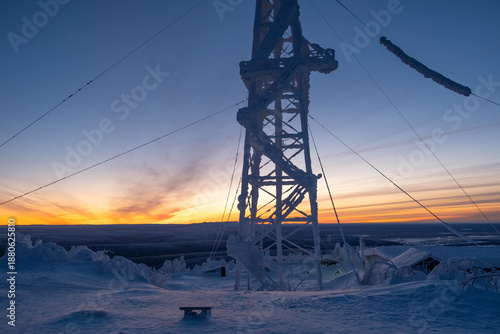 Snow-covered cap of the Polyud Mountain, shining brightly in the rays of the dawn sun. Perm Region