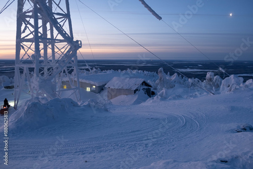 Snow-covered cap of the Polyud Mountain, shining brightly in the rays of the dawn sun. Perm Region