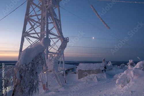 Snow-covered cap of the Polyud Mountain, shining brightly in the rays of the dawn sun. Perm Region