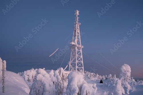 Snow-covered cap of the Polyud Mountain, shining brightly in the rays of the dawn sun. Perm Region