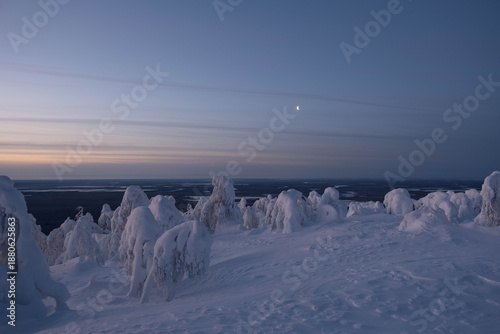 Snow-covered cap of the Polyud Mountain, shining brightly in the rays of the dawn sun. Perm Region
