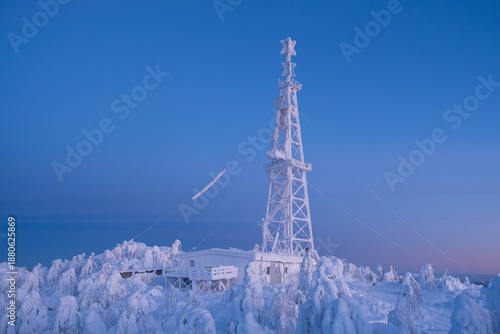 Snow-covered cap of the Polyud Mountain, shining brightly in the rays of the dawn sun. Perm Region