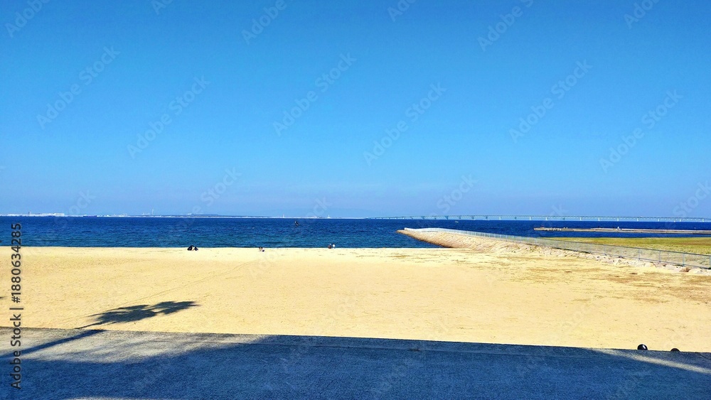 Obraz premium 秋の青空が広がる白い砂浜と穏やかな海の風景