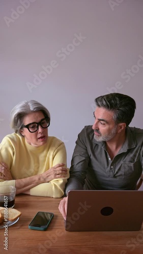 Mature couple using laptop computer together at home