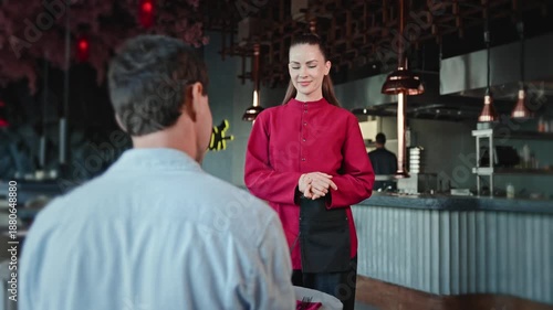 Wallpaper Mural Modern restaurant interior. Attractive waitress assisting male guest. Quality service experience. Torontodigital.ca