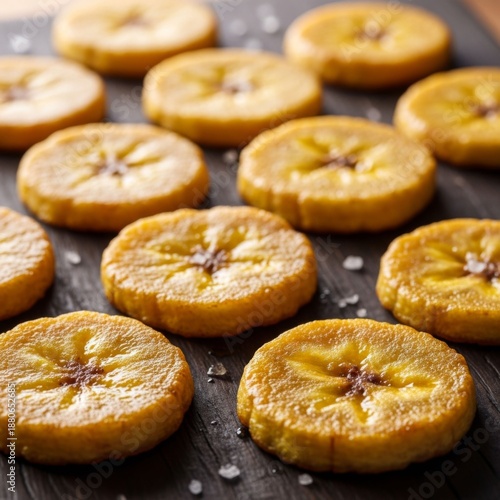 Crispy Fried Plantain Slices with Salt on Dark Wooden Background