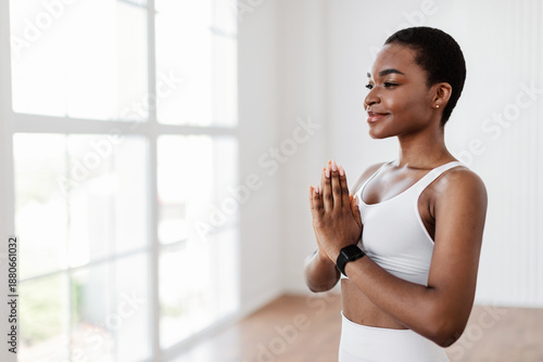 Mindfulness. Portrait of calm smiling black female athlete holding hands in prayer pose, keeping palms together, meditating, practicing Kundalini Yoga, looking aside at empty free copy space Free Download Mindfulness. Portrait of calm smiling black female athlete holding hands in prayer pose, keeping palms together, meditating, practicing Kundalini Yoga, looking aside at empty free copy space - GFXLoad
