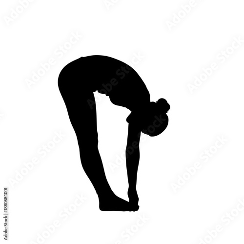 Silhouette of a woman performing a standing forward bend yoga pose.