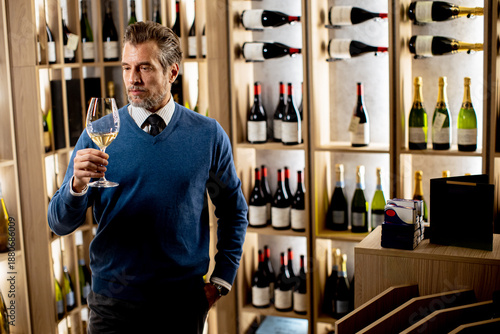 Elegant man enjoys wine in ...