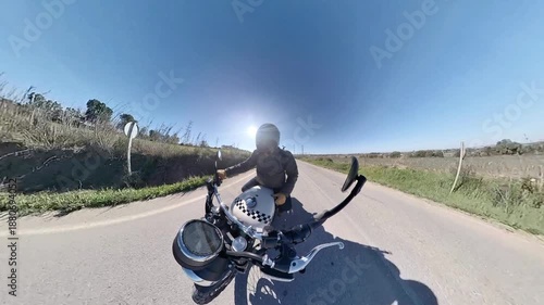 Chico con casco oscuro en motocicleta clásica rodando por carretera y bosque en día soleado ,toma grabada en 4k