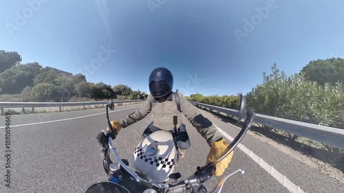 Chico con casco oscuro en motocicleta clásica rodando por carretera y bosque en día soleado ,toma grabada en 4k