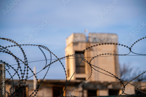 Barbed wire and a blurry bombed building at the UN buffer zone (Green line) in divided Nicosia, Cyprus.