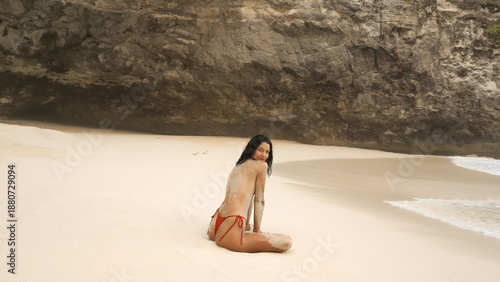 Foto Topless Model at Secluded Tropical Cove, Back View on Sandy Beach