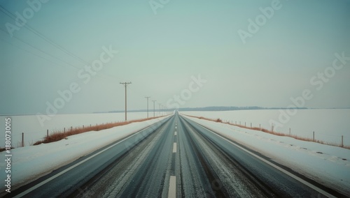Wide Road Stretches Through Snowy Landscape at Sunset in Winter Season