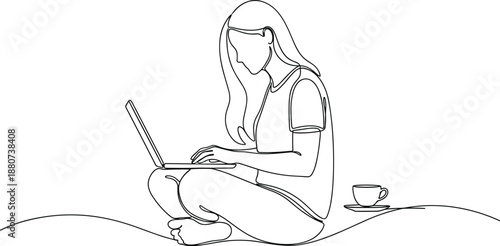 a young woman sitting cross legged and working on a laptop with a cup of coffee