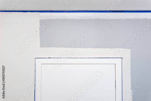 Preparing walls for painting, protecting door frames and ceilings with painters tape.