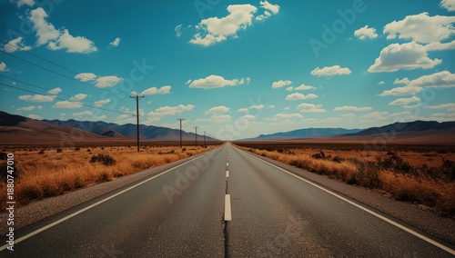 Wide Open Road Stretches Into Distant Land Under Blue Sky and Clouds on a Sun...