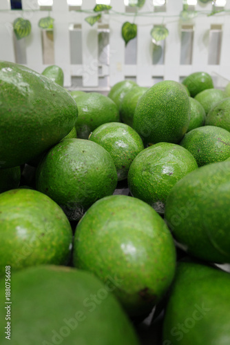 Close-up shot of a vibrant heap of fresh, ripe limes, showcasing their textured green skins. The artistic focus highlights the fruit's natural beauty in a rustic setting, perfect for healthy